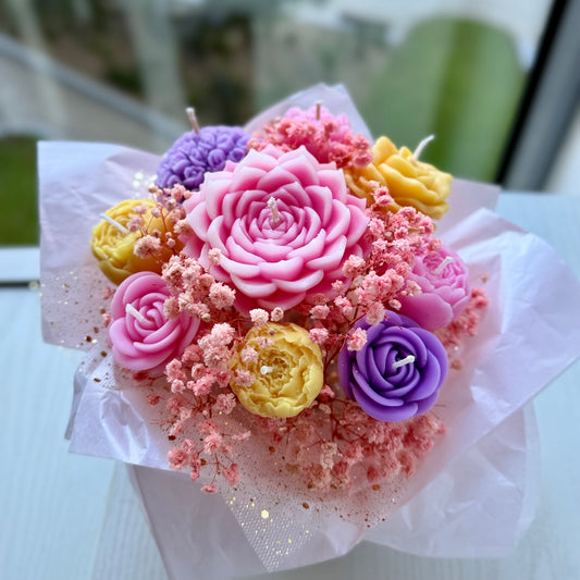 Handcrafted floral candle bouquet featuring pink, purple and yellow flower candles wrapped in tissue.